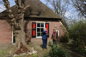 Vervangend burgemeester Hofland biedt de tweede druk van het boek over de Twentseweg aan Marie Jose Nijhuis van de Slikkebaard aan. Credit Omheining